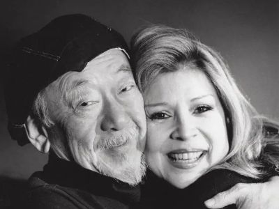 Pat Morita and Evelyn Guerrero are hugging each other in the picture.